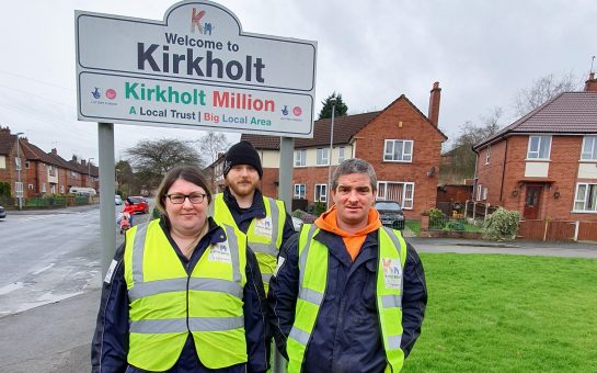 Three rangers, Coriena, Michael and Phil, stand by a sign to Kirkholt.