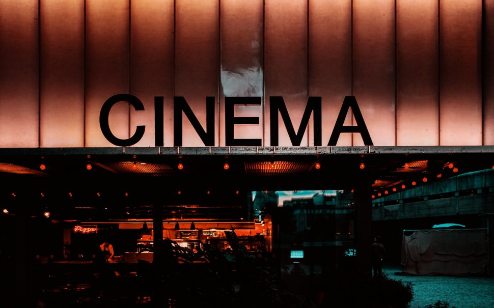 A photograph of the front of a cinema lit up with fluorescent lights