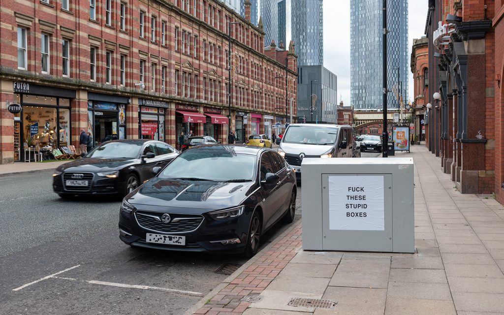 Photo of box on Deansgate with notice in all caps: "FUCK THESE STUPID BOXES."