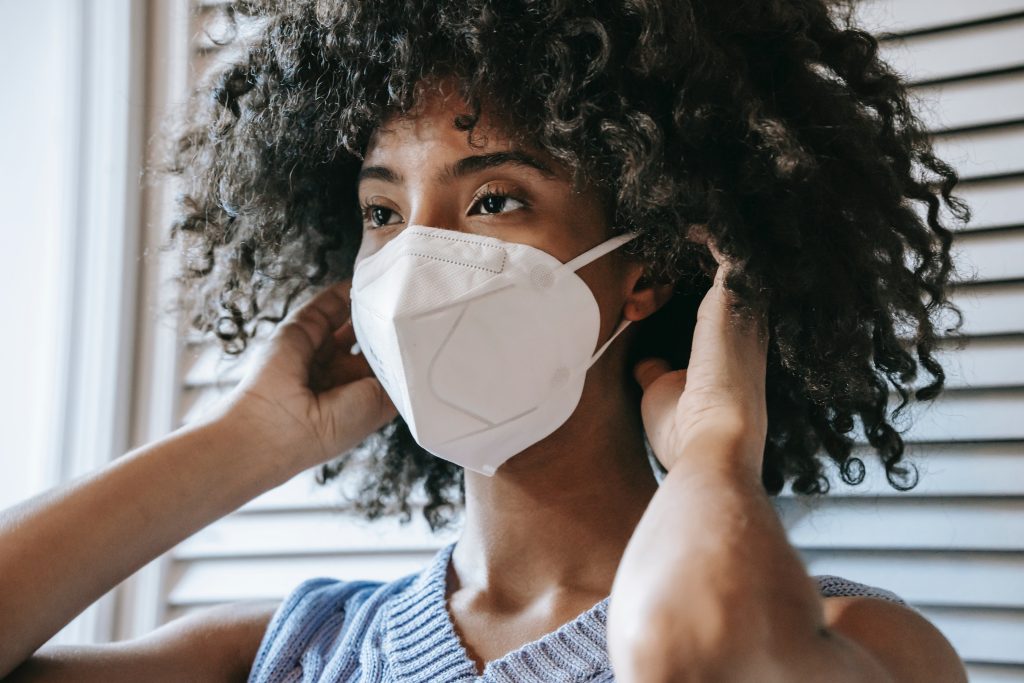 woman putting on face mask