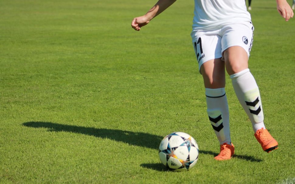 women controlling a football