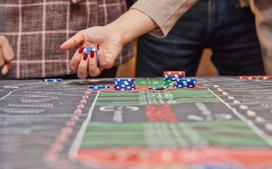 someone with chips and dice at a casino