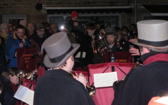 Hebden Bridge Junior Band play carols in a crowded Town Square