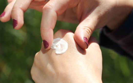 Person rubbing cream on their skin