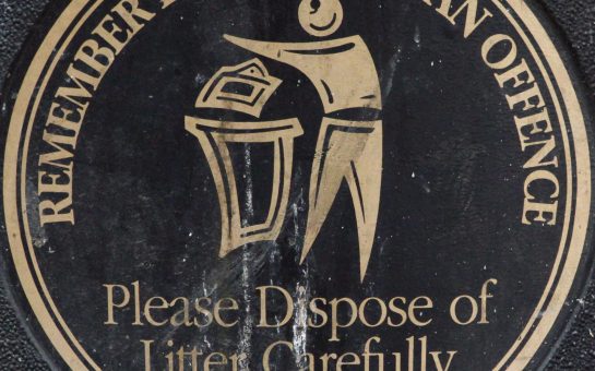 A Manchester sign reading "Please remember littering is an offence. Please dispose of litter carefully."