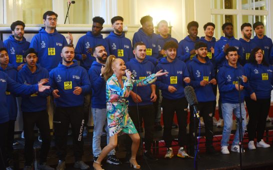 Sonia singing in front of a choir