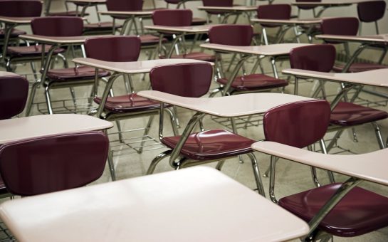 A series of desks with crimson metal chairs