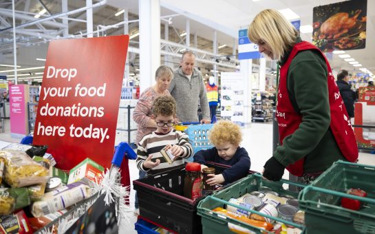 children placing food items in collection baskets at Tesco for food collection