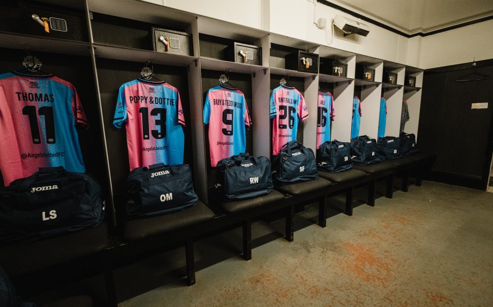 Photo of blue and pink Angels United FC kit hung in dressing room.