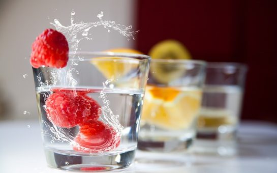 Photograph of clear drinking glasses featuring ice cubes and fruit