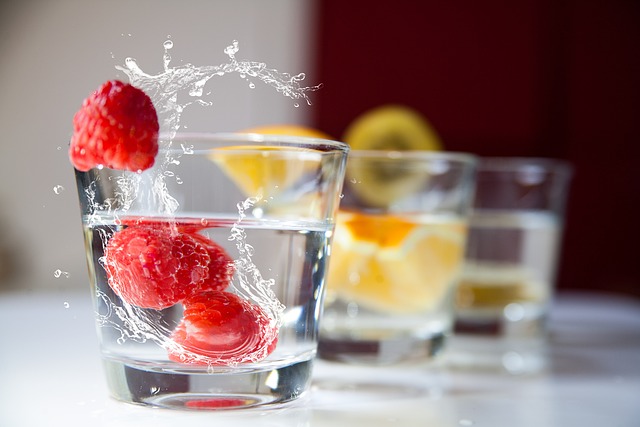 Photograph of clear drinking glasses featuring ice cubes and fruit