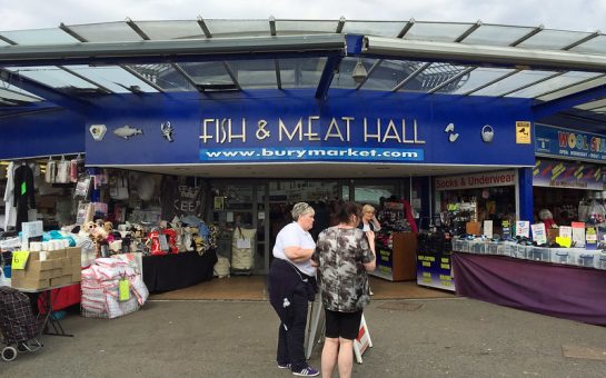 Bury Market Fish and Meat Hall entrance with three people outside