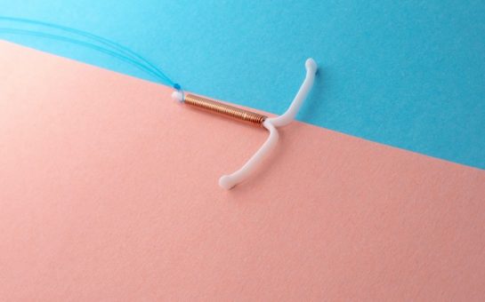 A coil on a geometric pink and blue graphic background