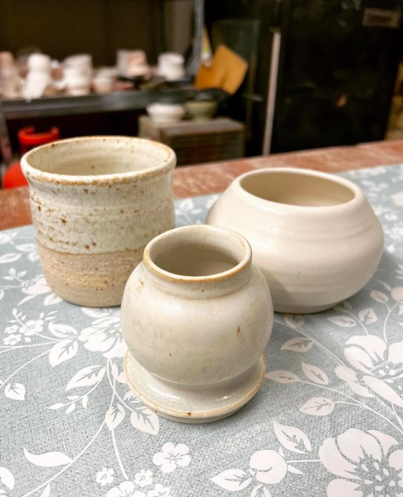 Three ceramic pots on a table.