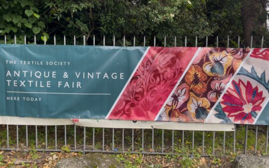 Banner showing the words "The Textile Society, Antique & Vintage Textile Fair Here Today"