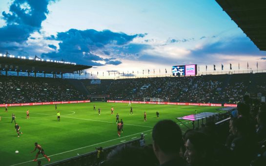 Fans watching a football match in a stadium (Credit: Free to use from Unsplash)