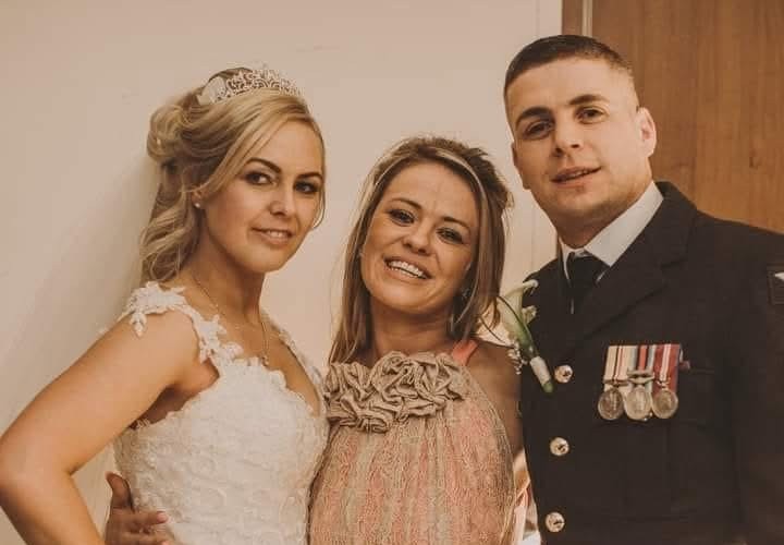 Image shows three siblings, two blonde women and one male. One of the women is in a wedding dress and the man is dressed in a military uniform.