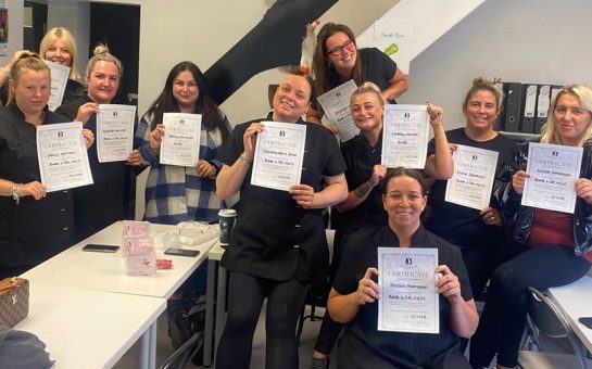 Manchester-based Feel Good Futures Training CIC. A group of female trainees holding up their certificates earned proudly.