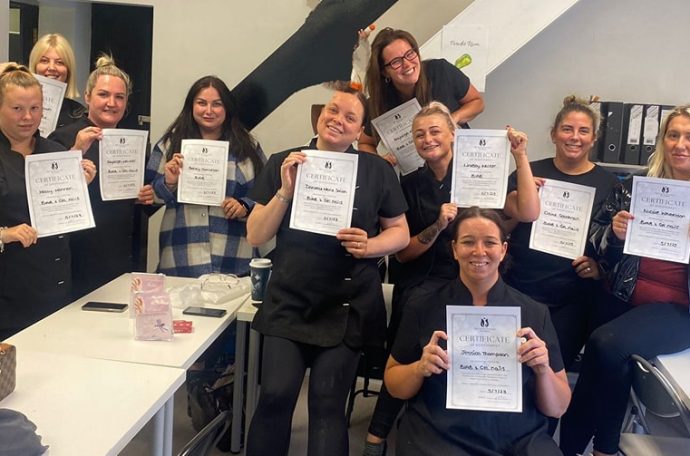 Manchester-based Feel Good Futures Training CIC. A group of female trainees holding up their certificates earned proudly.