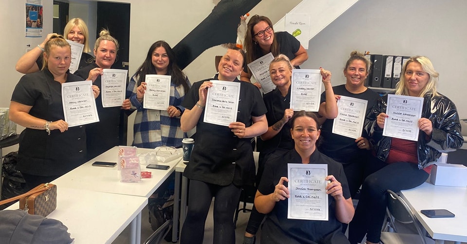Manchester-based Feel Good Futures Training CIC. A group of female trainees holding up their certificates earned proudly.