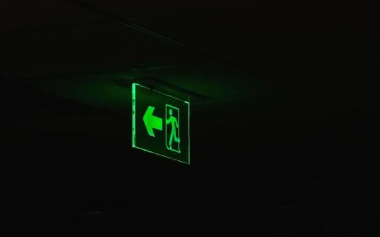 Glowing green emergency exit sign in