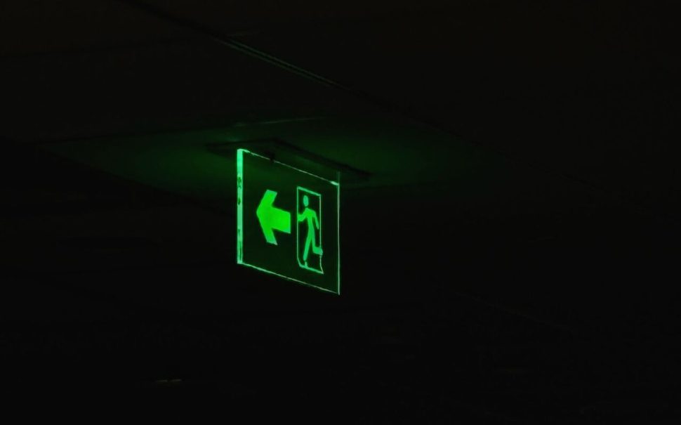 Glowing green emergency exit sign in